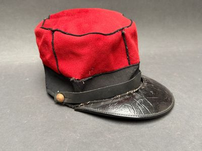 un chapeau rouge orné d'un ruban noir sur le dessus
