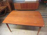 a wooden table with two drawers and a cabinet in the background