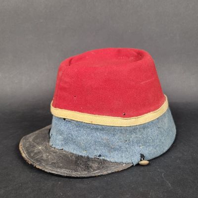 un chapeau rouge et bleu posé sur une surface noire
