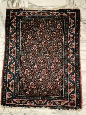 a rug on a marble floor with a white wall behind it