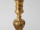 a gold colored candle holder on a white table