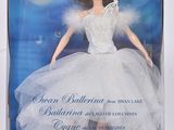 La poupée porte une robe blanche et un ruban à nouer