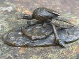 une statue représentant une tortue assise sur un rocher
