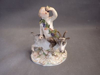 a figurine of a woman sitting on a goat