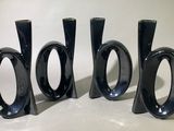 trois vases noirs posés les uns à côté des autres sur une table