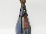 un vase bleu orné d'un homme, posé sur un fond blanc