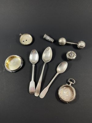 plusieurs cuillères en argent et d'autres couverts en argent posés sur un fond noir