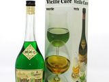 des bouteilles de vin et une boîte de verres à vin posés sur une surface blanche