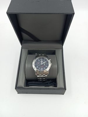 une image représentant une montre dans un écrin noir posé sur une surface blanche