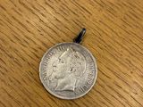 a silver coin sitting on top of a wooden table