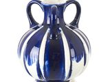 un vase bleu et blanc posé sur une surface blanche