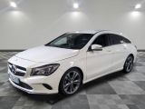Une Mercedes CLA blanche est garée dans une grande pièce