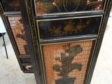 a black and gold cabinet with a flower design on it