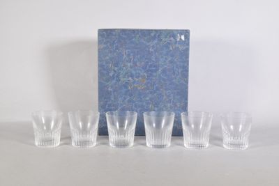 six verres à shot et un livre bleu posés sur une table