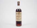 une vieille bouteille d'alcool posée sur une surface blanche