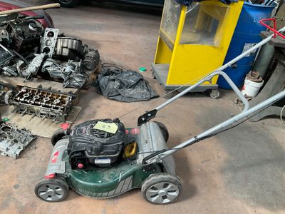 a lawn mower sitting on the ground in a garage