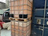 un homme debout à côté d'une pile de fûts