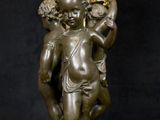 a bronze statue of a man and woman holding a candelabra