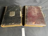 two old books sitting on top of a table next to each other