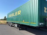 un semi-remorque vert garé sur le bord de la route