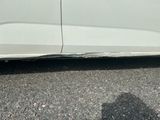 une voiture blanche qui a été repeinte en blanc et qui présente un trou sur le côté