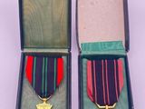 deux médailles dans une boîte ornée d'un ruban et d'une croix