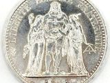 an image of a silver coin with a picture of three people on it