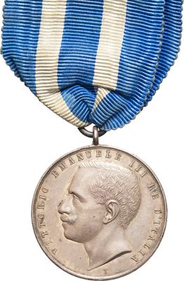 an old medal with a blue and white ribbon around it