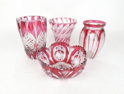 three red glass vases sitting next to each other on a white surface