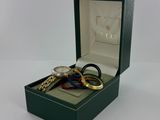 a box with a watch and two rings inside of it