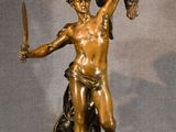 bronze statue of a man holding a sword and a shield