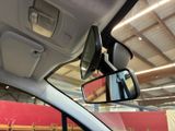 a rear view mirror of a car with a red wall in the background