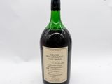 une vieille bouteille de vin posée sur une table blanche