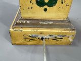 yellow and green painted clock with a musical instrument on it ' s side