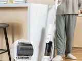 a woman standing next to a vacuum cleaner on the floor