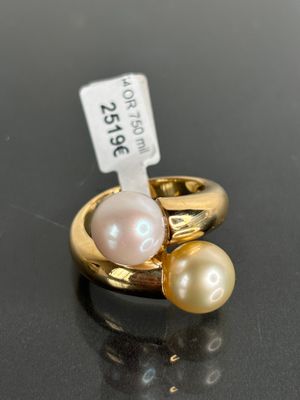 a close up of a ring with two pearls and a price tag