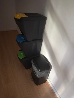 a black trash can and a black trash can next to each other