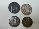 quatre types différents de pièces d'argent sur une surface blanche