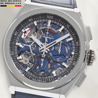 a close up of a wrist watch with a blue strap
