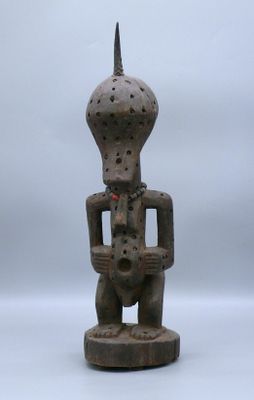 une vieille statue en bois représentant un homme tenant un bébé dans ses bras