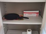 a small cabinet with a toilet and a pot and pan on it