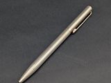 un stylo argenté posé sur une surface noire
