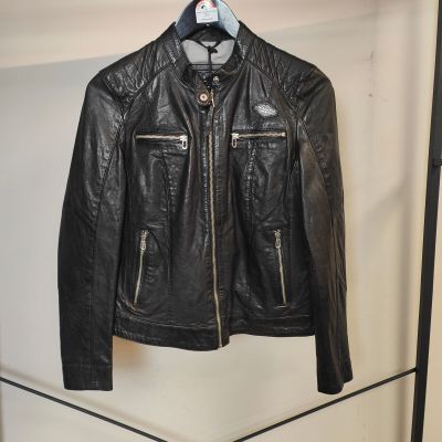 une veste en cuir noir accrochée à un porte-vêtements dans une pièce