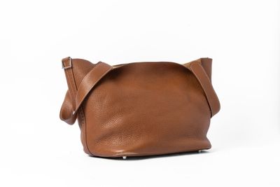 un sac en cuir marron muni de deux anses et d'une bandoulière