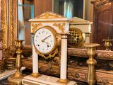 a clock that is sitting on a table in front of a mirror