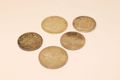 several coins are arranged in a triangle on a white surface