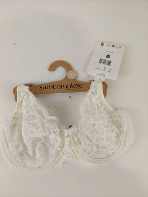 a close up of a white bralette on a hanger on a wall