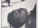 black and white photograph of a young boy looking up at a skateboarder