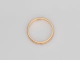 gros plan d'une bague en or sur une surface blanche