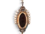 a close up of a pendant with pearls on a white background